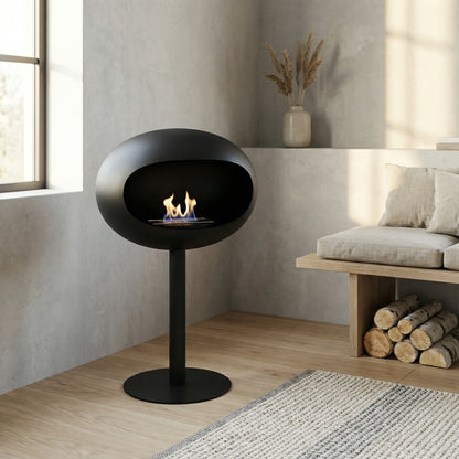 Cheminée éthanol sur pied noire dans salon minimaliste avec bois clair.
