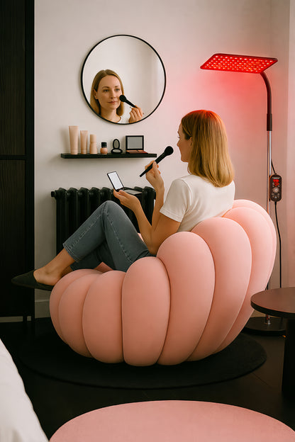 Lampe de luminothérapie rouge sur pied éclairant le visage pendant une routine maquillage et soin de la peau à domicile.
