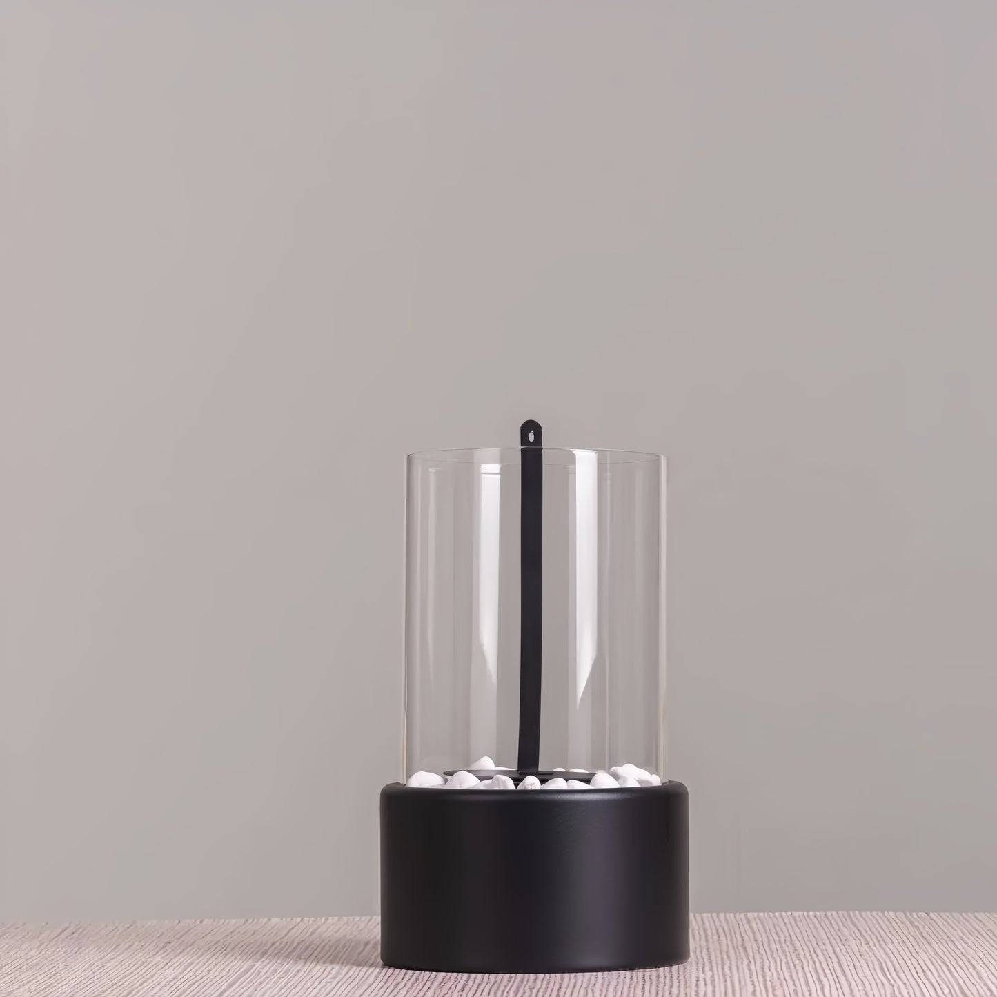 Silhouette sobre et sculpturale de la cheminée de table éteinte, soulignant son rôle d'objet de design intérieur.