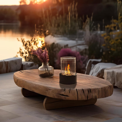 Foyer extérieur portable posé sur une table en bois massif au bord de l'eau, illustrant son usage nomade en terrasse.