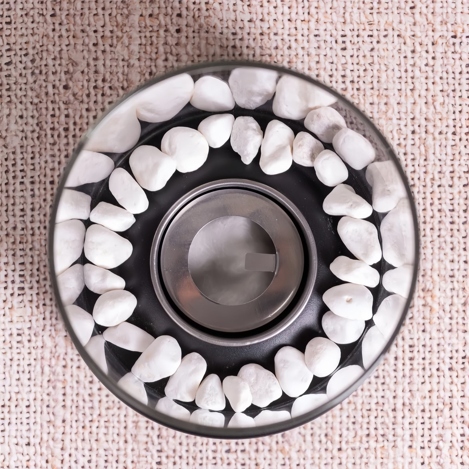 Vue aérienne montrant les galets de rivière blancs entourant le brûleur en acier inoxydable de la cheminée ronde.