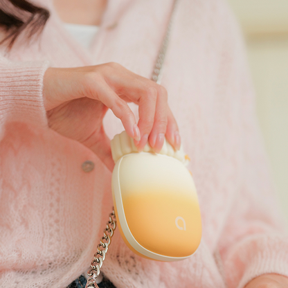 Main tenant le chauffe-main Pétale pour illustrer sa texture soft-touch et son ergonomie.