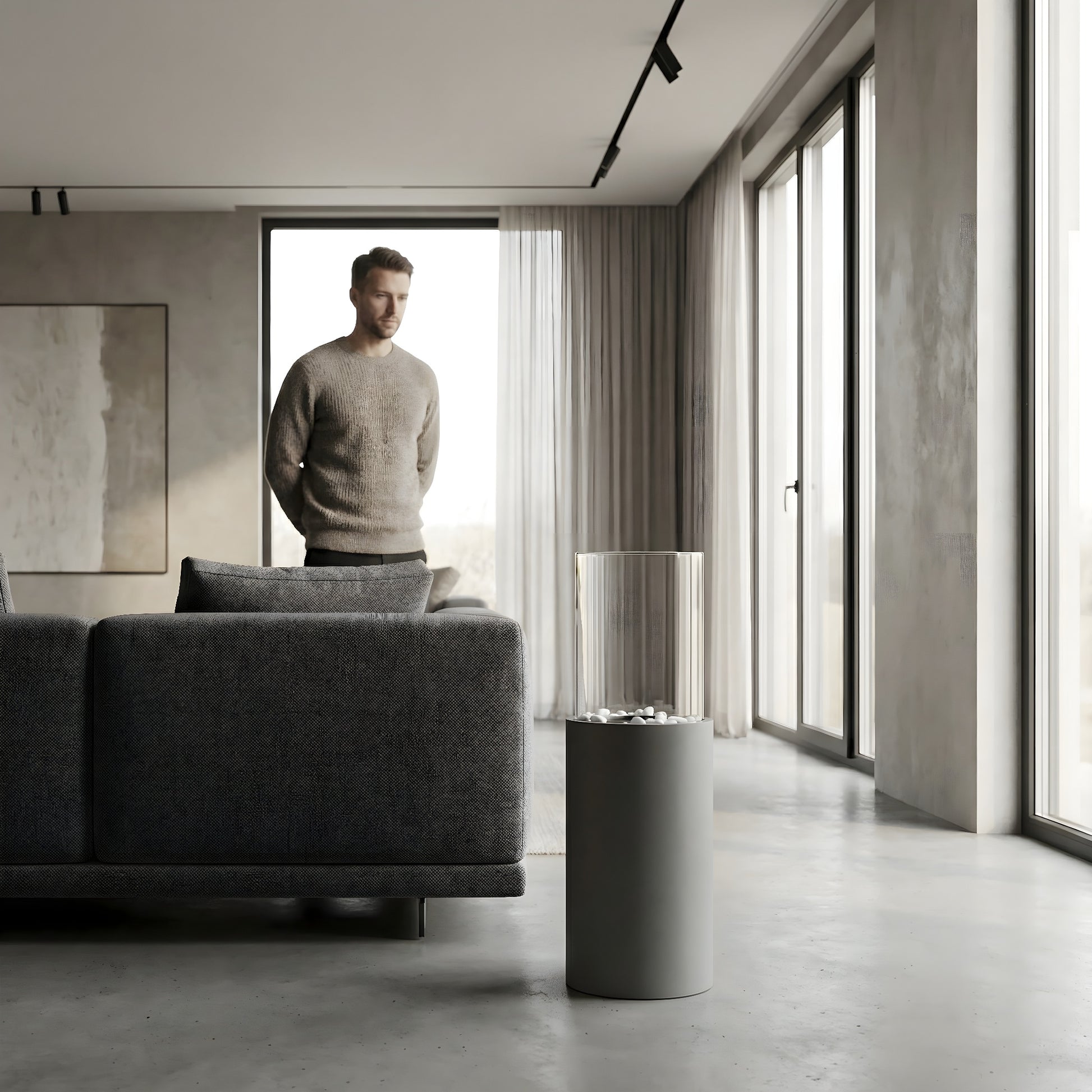 Cheminée éthanol cylindrique Calora Home dans un salon moderne et épuré, homme debout près du canapé