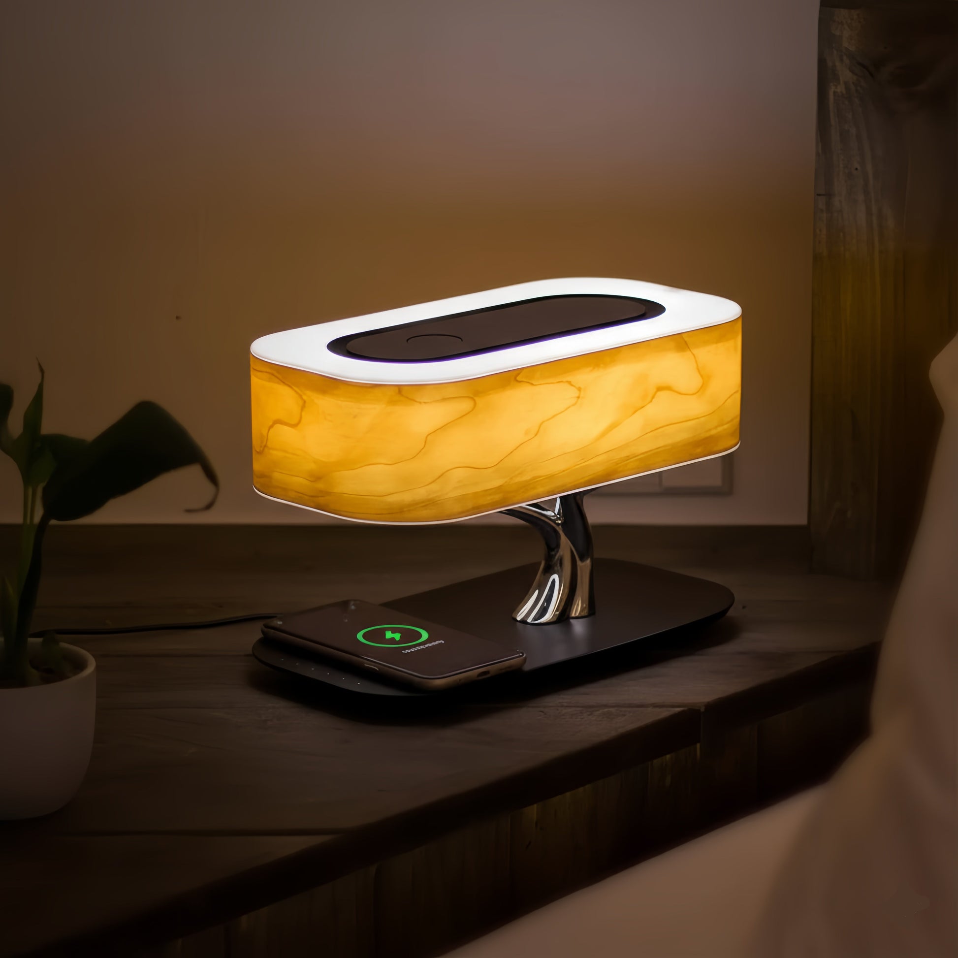 Lampe de chevet LED design bois et chrome avec chargeur sans fil Qi intégré pour smartphone, enceinte Bluetooth et éclairage tamisé.